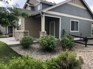 A low-maintenance front yard landscape featuring decorative rocks and shrubs by Front Range Finest in Fort Collins, CO.