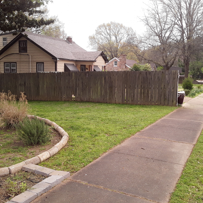 A front yard with neatly mowed grass and well-maintained landscaping by Christian Lawncare Services in Memphis, TN.
