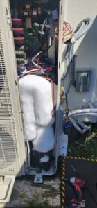 A frozen HVAC coil inside an outdoor unit, indicating a problem requiring diagnosis and repair by Nelke Mechanical in Keizer, OR.