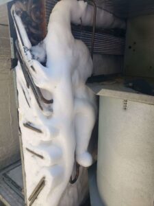 A completely frozen evaporator coil inside an HVAC unit, requiring urgent repair service from Vertex Heating & Cooling in Buckeye, AZ