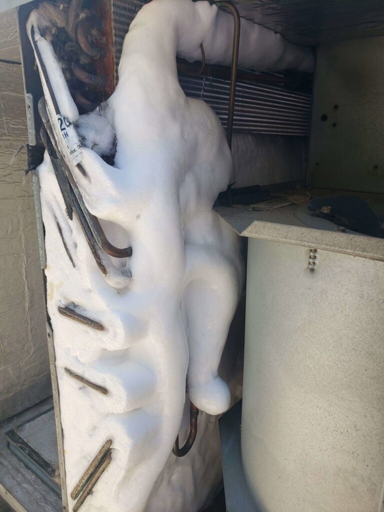 A completely frozen evaporator coil inside an HVAC unit, requiring urgent repair service from Vertex Heating & Cooling in Buckeye, AZ