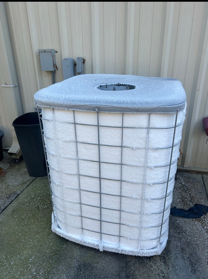 A frozen outdoor HVAC unit covered in snow, indicating a potential service need from Southern Comfort Heating & Air, LLC in Chattanooga, TN.