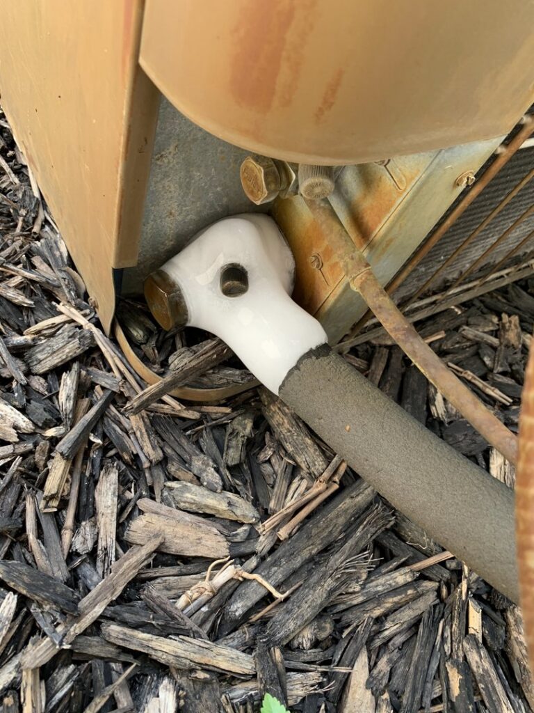 A close-up of a frozen refrigerant line on an outdoor AC unit, indicating a service call for I & M Heating and Cooling in South Bend, IN.