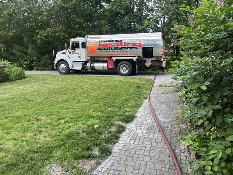A Maine Heating Solutions fuel delivery truck with a hose, providing heating oil or propane in South Portland, ME.