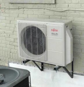 A Fujitsu Halcyon mini-split outdoor unit mounted on a brick wall, installed by Eastern Air Flow of Kentucky in Richmond, KY.