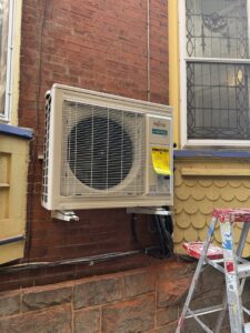 A Fujitsu mini-split outdoor unit newly installed on a brick wall by Air Done Right in Philadelphia, PA.