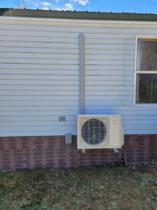 An outdoor Fujitsu mini-split unit professionally installed on a residential building by Maine Thermal Energy Services in Ellsworth, ME