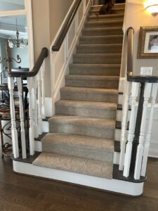 A fully carpeted staircase with light brown carpet, expertly installed by Kimi's Carpets Plus in Cary, NC