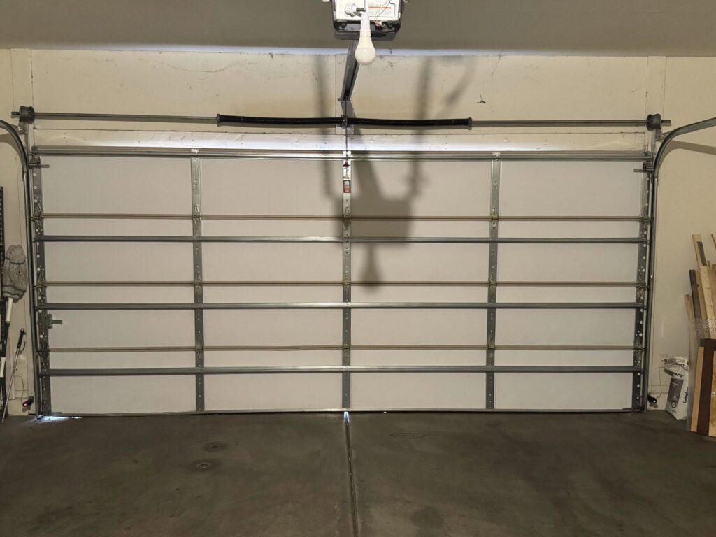 A full interior view of a white garage door showing panels and tracks, installed by 4 Sons Garage Door in Phoenix, AZ.