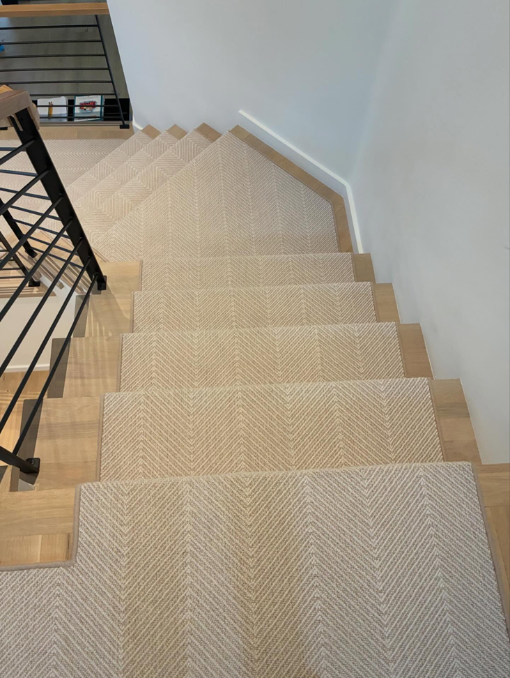 Overhead view of a complete staircase carpet installation with a herringbone pattern by Trademark Flooring in West Jordan, UT.