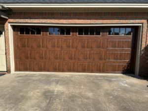 A full view of a newly installed brown garage door with windows on a brick house by Mike's Garage Door Repair in Wetumpka, AL.
