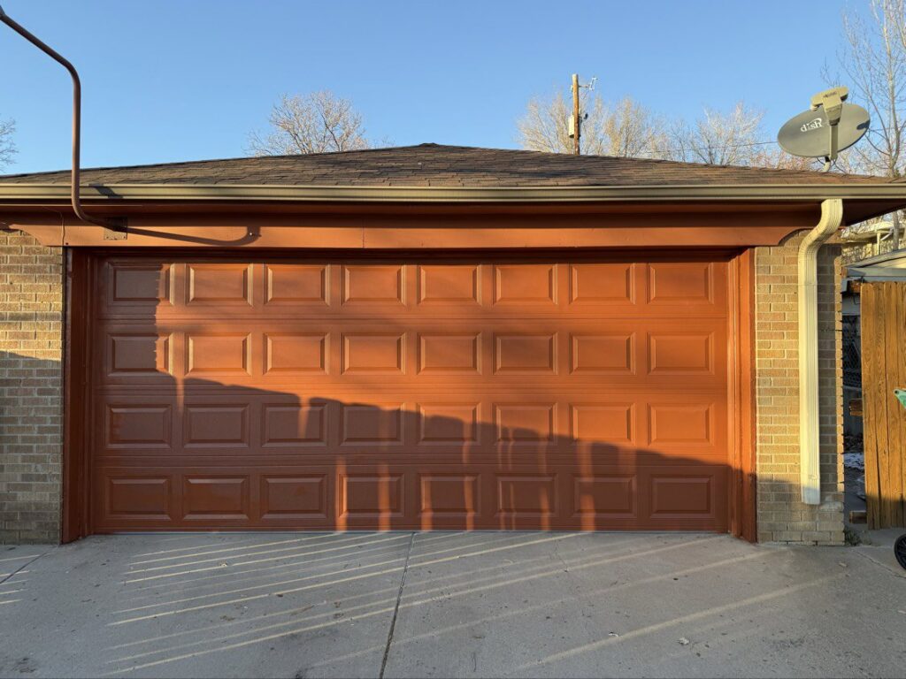 A full exterior view of a brown panel garage door installed by Colorado Garage Door Guy in Aurora, CO.