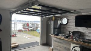Open full-view glass garage door on a boathouse, installed by Superior Overhead Door, LLC in Granger, IN
