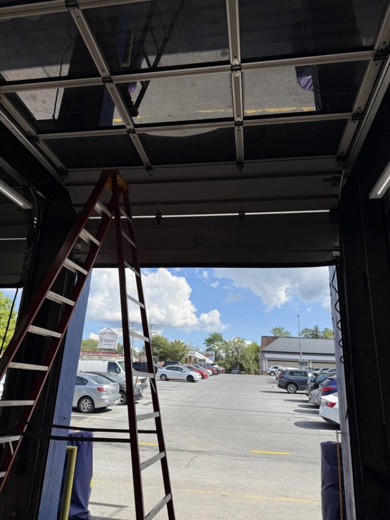 A full-view glass garage door being installed or serviced by Universal Overhead And Garage Doors in Baltimore, MD.