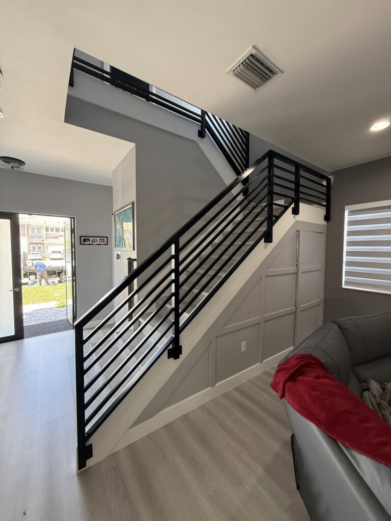 A full view of a modern black metal stair railing installed by Osuna Ornamental Fences & Gates in Cutler Bay, FL.