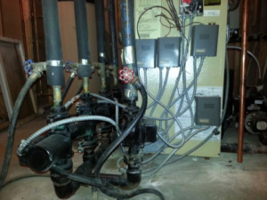 An HVAC furnace or air handler unit with connected ductwork installed by Antigua Mechanical in Manchester, NJ.