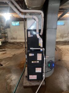 A furnace and air handler unit with ductwork in a basement, installed by One Hour Heating & Air Conditioning of Springfield in Springfield, MO.