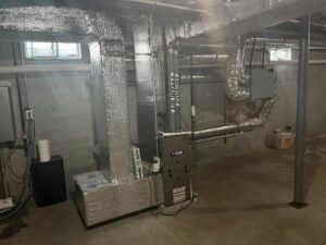 A new furnace and air handler unit with extensive ductwork installed in a basement by All Points HVAC in Worcester, MA.