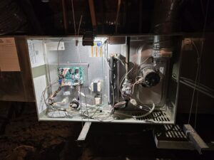 An open indoor furnace or air handler unit showing internal components during inspection by Quantum Cooling & Heating in Mesa, AZ.