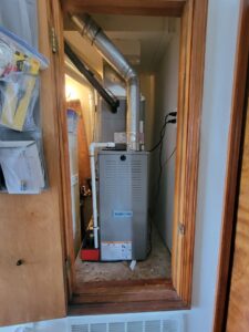 A furnace and air handler unit installed in a utility closet by Pacheco Air Conditioning and Heating LLC in Albuquerque, NM.