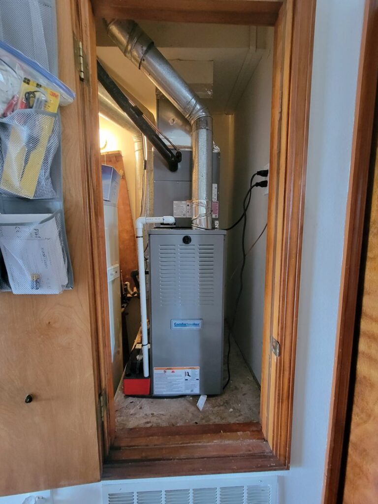 A furnace and air handler unit installed in a utility closet by Pacheco Air Conditioning and Heating LLC in Albuquerque, NM.