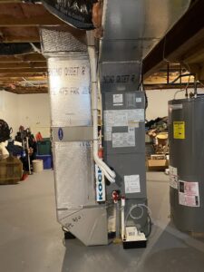 A new furnace and air handler unit with ductwork and a water heater installed in a basement by RSC Heating and Air Conditioning in Lancaster, PA.