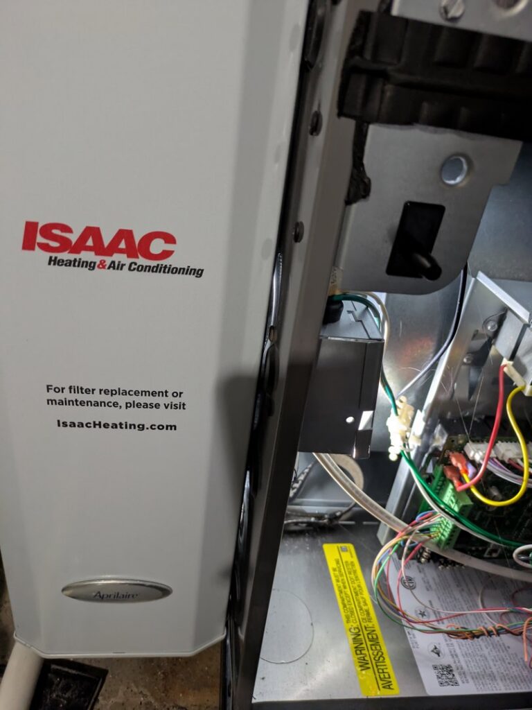 An interior view of a furnace or air handler with Isaac Heating & Air Conditioning branding in Rochester, NY.