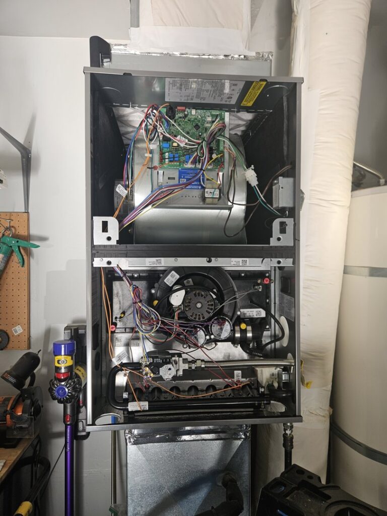 An open furnace or air handler showing internal components and wiring, serviced by Conrad Heating and Cooling in Beaverton, OR.
