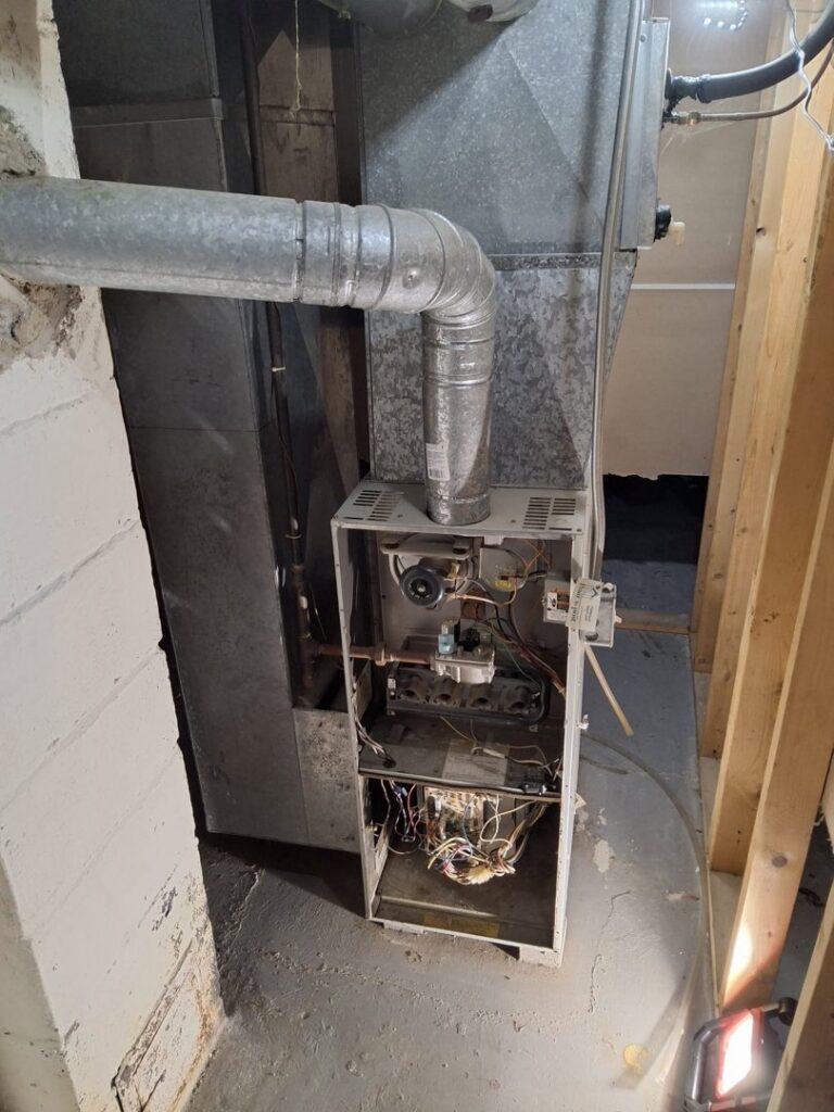 An open furnace or air handler unit showing internal components, indicating service by Nimmer Heating & Air Conditioning in Milwaukee, WI.