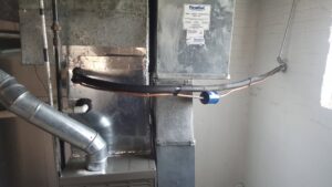 An interior view of a furnace or air handler unit with connected ductwork and refrigerant lines, installed by Mid-City HVAC, INC. in Chicago, IL.