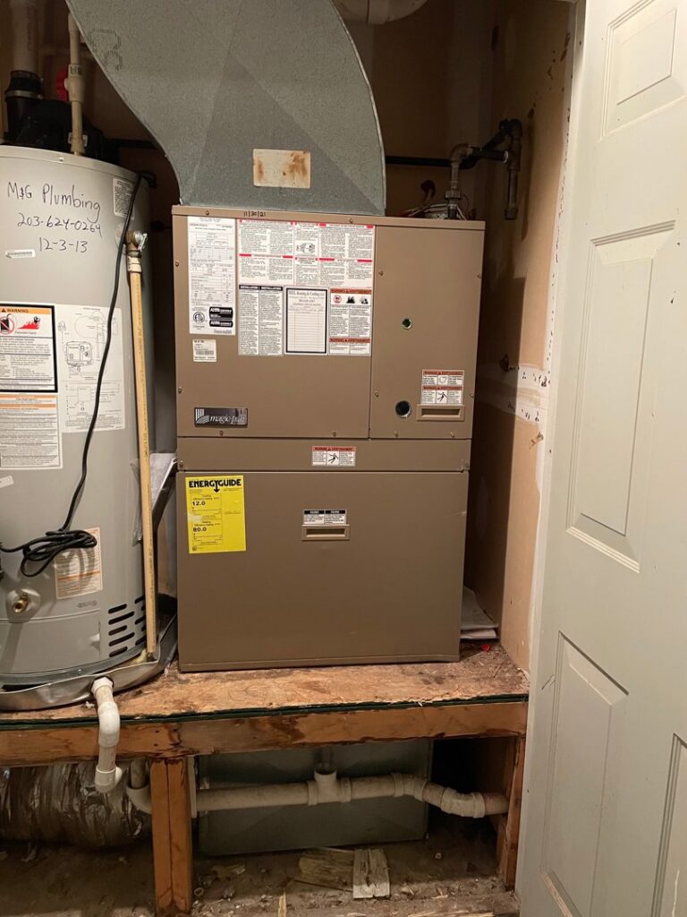A furnace and air handler unit installed next to a water heater by MTL Heating and Cooling LLC in West Haven, CT