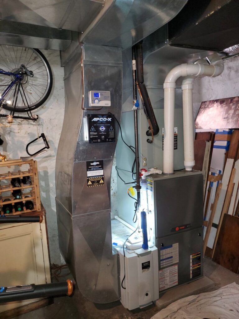 An indoor furnace and air handler unit with an APCO-X air treatment system installed by Bouvy Heating & Air Conditioning Services in Pittsburgh, PA.
