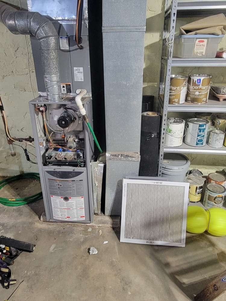 An indoor furnace or air handler unit with an open panel and a dirty air filter next to it by Friess Heating & Air Conditioning in Topeka, KS