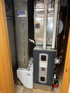 A furnace and air handler unit with an air purifier and ductwork, installed by Comfort Craftsman Heating & Cooling in Westland, MI.