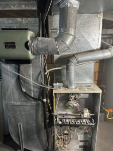An existing furnace and humidifier system with ductwork, representing heating services by All Around Heating & Cooling in Akron, OH.