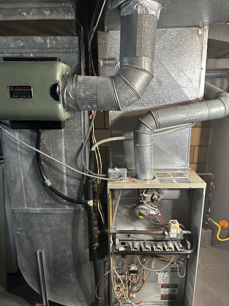 An existing furnace and humidifier system with ductwork, representing heating services by All Around Heating & Cooling in Akron, OH.