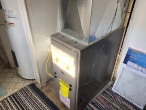 An indoor furnace unit next to a water heater, serviced by Butte Heating & Cooling in Rapid City, SD.