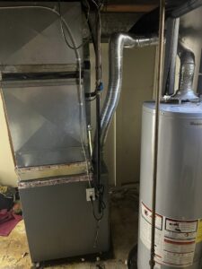 An indoor furnace and water heater installation with ductwork by Motown Mechanical Heating And Cooling in Westland, MI.
