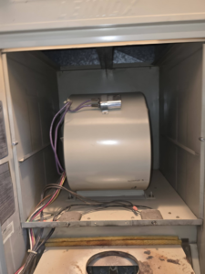 A furnace blower motor and fan housing inside an HVAC unit by Affordable Quality Air Duct Cleaning in Denver, CO