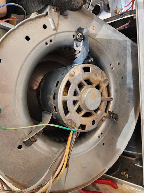 A close-up view of a furnace blower motor, likely during an inspection or repair by Bloomington Heating & Air in Bloomington, MN.