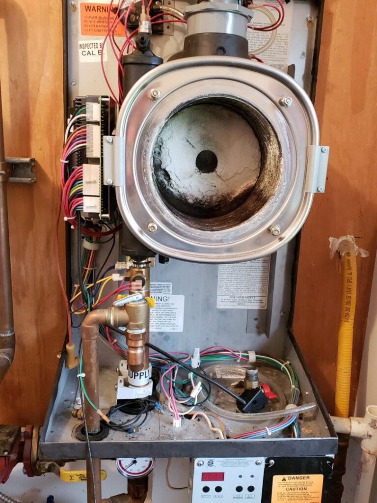Internal components of a furnace or boiler unit, showing wiring and burner, serviced by TruTemp Heating & Cooling LLC in Ijamsville, MD.