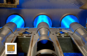 Close-up of a furnace burner with bright blue flames, showcasing heating system operation by Kerley Heating & Cooling in Rock City, IL
