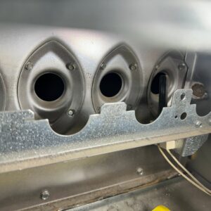 Close-up view of furnace burners and igniter during an inspection or service by Jump HVAC in Lakewood, CO.
