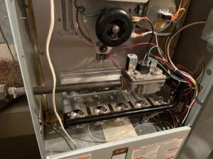 Close-up view of furnace burners and gas lines during an inspection or repair by Your HVAC Guy in Aurora, IL.