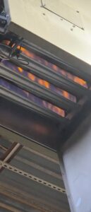 Close-up of furnace burners actively lit during an HVAC service by By the Bay Mechanical in Prince Frederick, MD
