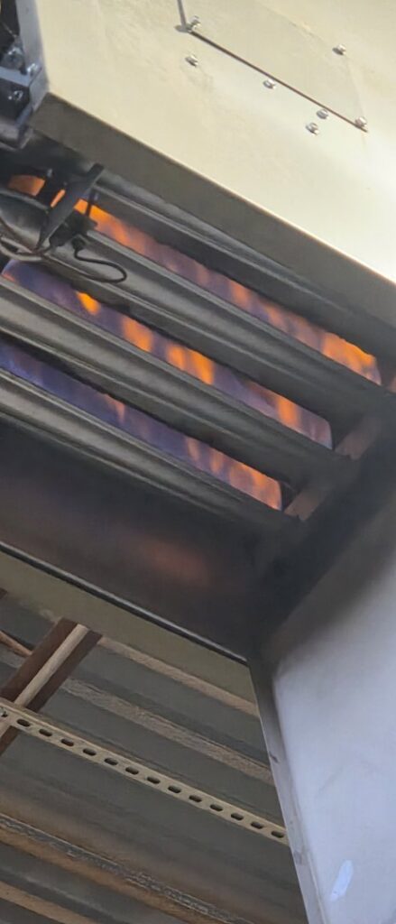 Close-up of furnace burners actively lit during an HVAC service by By the Bay Mechanical in Prince Frederick, MD