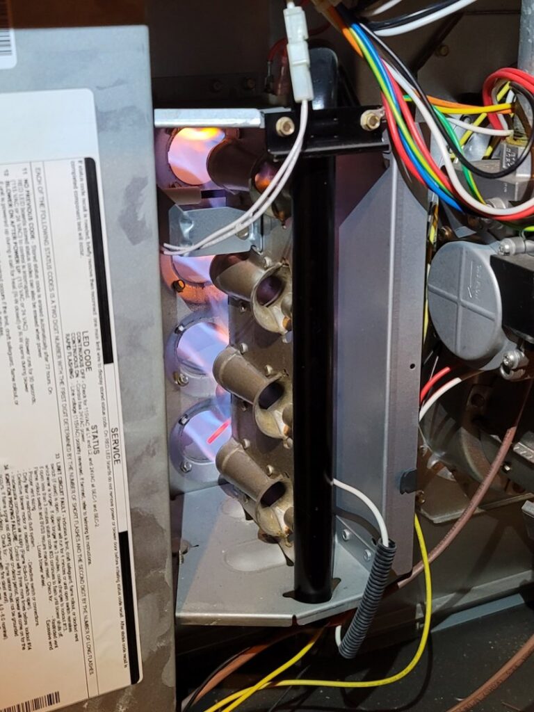 Inside a furnace with the burners lit, indicating proper operation during an HVAC service by Anubis Mechanical in Goose Creek, SC.