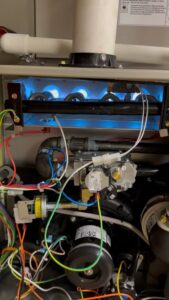 Inside a furnace showing the burners lit during an HVAC service by Carpenter Mechanical in Columbus, OH.