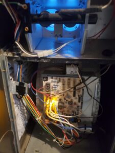 A close-up of a furnace circuit board with indicator lights and wiring during service by Done Right Air in West Allis, WI
