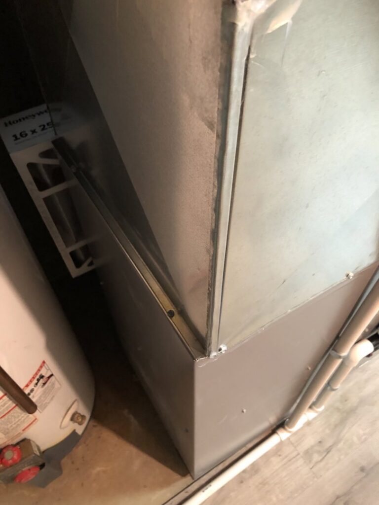 A furnace filter slot next to a water heater, indicating HVAC maintenance by Ohio City Heating and Cooling in Cleveland, OH.